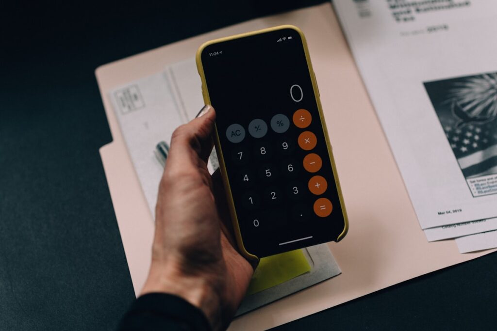 Boekhouder met rekenmachine en financiële documenten voor Belgische KMO